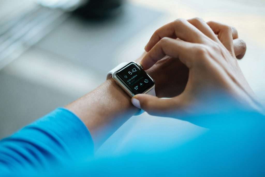 A patient using a smartwatch to access personalized health updates, illustrating how AI in healthcare improves engagement and communication .